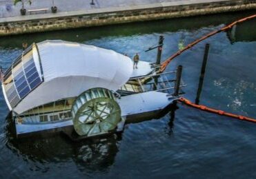 Solar powered water wheel cleans river